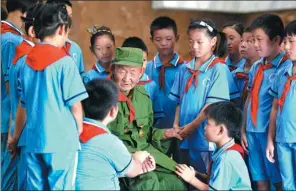  ?? MU YU / XINHUA ?? Students from a primary school in Nangong city, Hebei province, listen to Sun Yunbao, a veteran, at a local public cemetery honoring war martyrs.