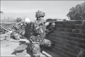  ?? AP/CHANNI ANAND ?? Indian soldiers take positions on a rooftop Saturday outside the air base in Pathankot, India, as troops on the ground search for gunmen who had attacked the base.