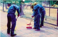  ??  ?? JUSTICE SERVED: Photo posted by the Dubai Media Office shows perpetrato­rs of cat video cleaning up premises of the zoo.