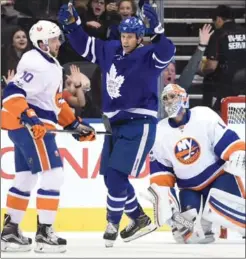  ?? FRANK GUNN, THE CANADIAN PRESS ?? Maple Leafs winger Matt Martin celebrates a goal as Islanders goalie Thomas Greiss and centre Alan Quine look on in Toronto on Tuesday. The Leafs won the game 7-1.