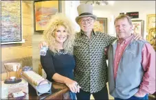  ?? Westside Eagle Observer/SUSAN HOLLAND ?? Gravette mayor Kurt Maddox (right) pauses for a photo with D. Arthur Wilson and his wife Lisa at the Art Gone Wild art gallery during the third Thursday gallery walk Thursday evening, April 15. Arthur and Lisa are owners of Art Gone Wild and the Heart and Soul Yoga Studio on Gravette Main. Arthur was organizer of the gallery walk and says he has inquiries from several other artists and he is expecting the third Thursday event to be even bigger and better in May.