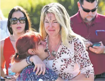  ?? JOEL AUERBACH/THE ASSOCIATED PRESS ?? Parents wait for news Wednesday after a shooting at Marjory Stoneman Douglas High School in Parkland, Fla. The shooter, a former student, killed 17 people and wounded more than a dozen, police said.