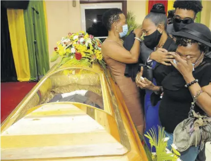  ?? (Photos: Garfield Robinson) ?? Doreen Hibbert, widow of Toots Hibbert, being consoled at her husband’s funeral yesterday.