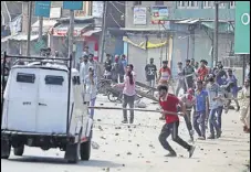  ?? WASEEM ANDRABI /HT ?? Protesters clash with security forces and throw stones at an army vehicle after the funeral of militant Yawar Nissar in Kashmir’s Anantnag district on Friday.