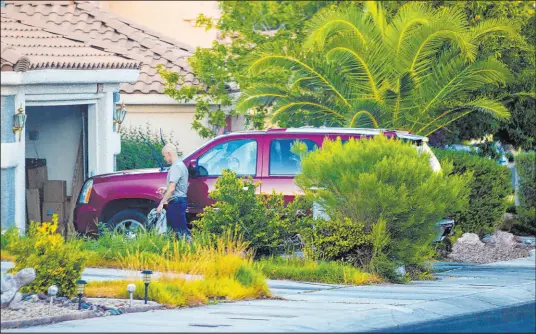  ?? Benjamin Hager
Las Vegas Review-journal ?? Clark County Public Administra­tor Robert Telles washes a car outside his home on Sept. 6, the same day police released pictures of the suspect’s car in Jeff German’s killing — a maroon GMC Yukon. The vehicle proved to be a crucial piece of evidence. R-J Director of Photograph­y Ben Hager was one of several staffers observing Telles for hours the day before he was arrested.