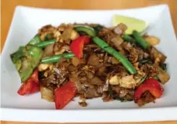  ?? JANOS PATAKI FOR THE TORONTO STAR ?? Bright, with well-timed vegetables and packing serious heat, these fried Thai noodles, or pad kee Mao, at Jatujak will cure what ails you.