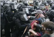  ?? JOSE LUIS MAGANA — THE ASSOCIATED PRESS ?? Capitol police officers in riot gear push back demonstrat­ors who try to break a door of the U.S. Capitol on Wednesday.