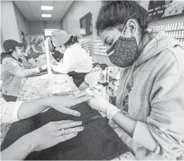  ?? NELVIN C. CEPEDA U-T FILE ?? Crystal Diaz works on a customer’s nails at a salon in Barrio Logan in March 2020. A local nonprofit will study COVID-19’s impact on small businesses.