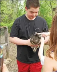  ??  ?? Daniel Roeder holds one of the school’s rabbits for visitors to pet.