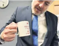  ??  ?? With his custom tea mug – Keep Calm You Are The First Minister