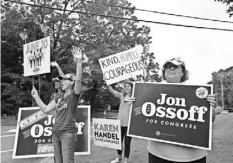 ?? JESSICA MCGOWAN, GETTY IMAGES ?? Jan Yanes and Tammy Harper of Roswell, Ga., supporters of Democratic candidate Jon Ossoff, wave at cars Tuesday.