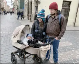  ?? The Canadian Press ?? Olena Boiko and her husband Volodymyr take their 10-month-old son Yaroslav for a walk in the city centre of Lviv, Ukraine on Saturday. Yaroslav was born in the bomb shelter of the hospital in Lviv a few months after the Russian invasion.