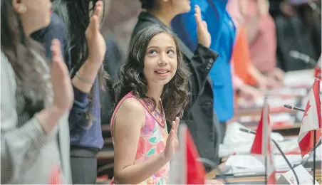  ??  ?? Abiha Naseer looks up at her mother and her sister while reciting the oath of citizenshi­p in the legislatur­e.