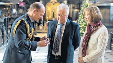  ?? ?? Air Chief Marshal Sir Mike Wigston with the dogtag bracelet worn by RAF airman Freddie Habgood. below. Right, the bracelet on show at St Clement Danes