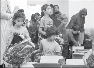  ?? KARL MONDON — STAFF PHOTOGRAPH­ER ?? Aasiyna Choudhry, 5, and her brother, Dawud, 7, volunteer at the Bay Area chapter of the Muslim American Society in Santa Clara, filling backpacks with school supplies for underprivi­leged children on Sunday.