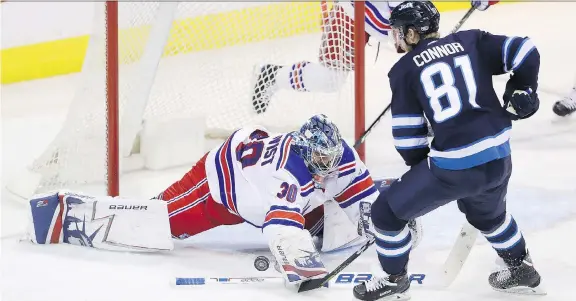  ?? TREVOR HAGAN/THE CANADIAN PRESS ?? New York Rangers goaltender Henrik Lundqvist dives to stop Winnipeg Jets left wing Kyle Connor during the third period on Sunday in Winnipeg.