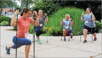  ?? MICHILEA PATTERSON — DIGITAL FIRST MEDIA ?? Lucie Bergeyova, far left, leads a seminar in Nordic Walking at the Pottstown Middle School. The group used the walking poles to do several stretches during the session.