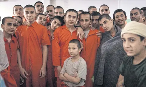  ??  ?? NO HOPE IN SIGHT: Young boys of various ethnicity stand for a picture in their crowded cell where they are being held, along with over 150 other minors, at a prison for former ISIS members run by Kurdish forces in northeast Syria.