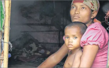  ?? AP PHOTO AP PHOTO ?? Rosmaida Bibi, who suffers from severe malnutriti­on, sits on her mother Hamida Begum’s lap at their makeshift shelter at the Dar Paing camp, north of Sittwe, Rakhine State, Myanmar.