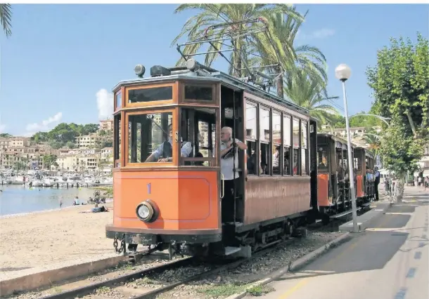  ?? FOTO: FERROCARRI­L DE SÓLLER/DPA ?? Die als „Roter Blitz“bekannte Straßenbah­n fährt durch Port de Sóller.