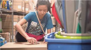  ??  ?? Student volunteer Homerose Uy works with the Memphis Medical District Collaborat­ive to help assemble combinatio­n refrigerat­ormicrowav­es for patient families at Ronald McDonald House.