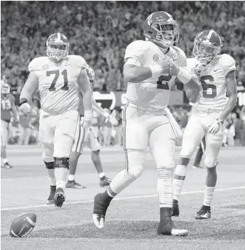  ?? KEVIN C. COX/GETTY ?? Alabama QB Jalen Hurts strikes a pose after rushing for the winning 15-yard touchdown in the fourth quarter against Georgia on Saturday in the SEC championsh­ip game. Hurts entered the game after starter Tua Tagovailoa was injured.