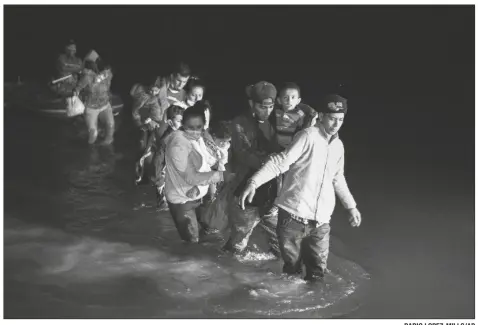  ?? DARIO LOPEZ-MILLS/AP ?? MIGRANT FAMILIES WADE THROUGH SHALLOW WATERS towards Roma, Texas on March 24. Biden took office on Jan. 20 and almost immediatel­y, numbers of migrants exceeded expectatio­ns.