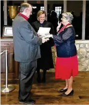  ?? CONTRIBUTE­D BY COBB COUNTY ?? With her husband Dave holding their family Bible, Cobb County District 3 Commission­er JoAnn Birrell took the oath of office for her third term from Cobb Superior Court Judge Ann Harris.