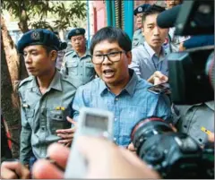 ?? SAI AUNG MAIN/AFP ?? Detained journalist Wa Lone (centre) is escorted to a police van from a courthouse after attending his trial in Yangon on April 4.