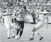  ?? ROSA CAVALCANTI/COURTESY ?? Strikers midfielder Marlon Freitas splits two Atlanta defenders in the first half of the match on Saturday.