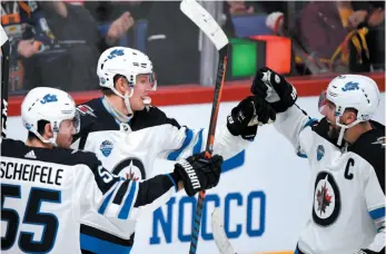  ?? AP PHOTO ?? Patrik Laine of Winnipeg Jets, centre, celebrates with Mark Scheifele and Blake Wheeler after scoring his team’s second goal during the NHL Global Series Challenge game against the Florida Panthers in Helsinki, Finland, on Thursday.