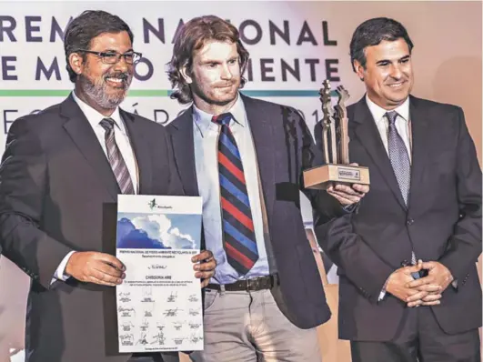 ??  ?? Al centro de Izquierda a derecha: Diego Pini, director País de ACCIONA y José Ignacio Escobar, gerente general de ACCIONA
Chile, reciben el Premio Nacional de Medio Ambiente Recyclápol­is 2017, en la Categoría Aire.