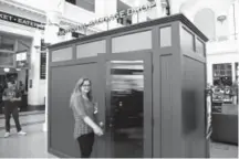  ??  ?? Denver resident Leah Podzimek on Friday takes part in “Emotional Baggage Drop,” one of many features in the project “Happy City Denver: Art for the People” at Union Station. The room, which is divided by a wall, allows strangers to visit.