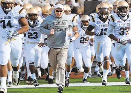  ?? KEVIN MINGORA/THE MORNING CALL ?? Lehigh University’s head football coach Andy Coen center, leads the Mountain Hawks onto the field prior to the start of their game against Lafayette Saturday, Nov. 20, 2010.