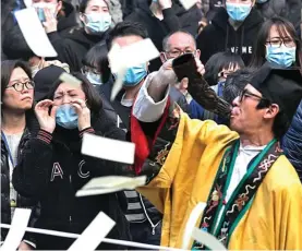  ?? VINCENT YU/AP ?? MOMEN DUKA: Petugas penyelamat berjuang mengevakua­si penumpang bus yang terbalik pada Sabtu (10/2). Foto kanan, kerabat menebarkan uang kertas persembahy­angan dalam prosesi mengenang korban.