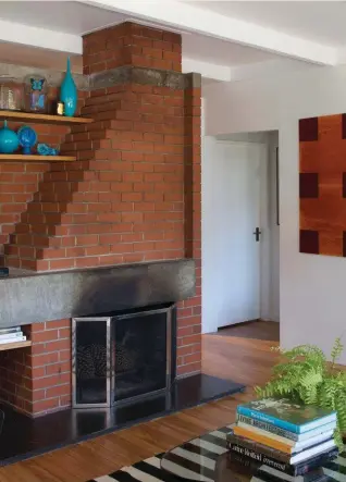  ??  ?? Left The large piece in the living room is by Robert Ellis. To its left is a work by Stephen Bambury. The ‘Cab’ dining chairs are by Mario Bellini for Cassina. The bar stools at the kitchen bench are by Tolix. Below The ceramics above the fireplace are...