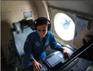  ?? (AP/Gemunu Amarasingh­e) ?? Nikki Hathaway, a meteorolog­ist and flight director of National Oceanic and Atmospheri­c Administra­tion’s WP-3D Orion “hurricane hunter” aircraft, sits at her workstatio­n in the plane.