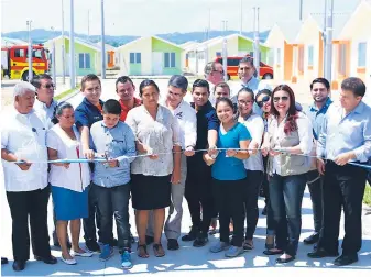  ??  ?? HOGAR. Juan Orlando Hernández junto a las familias beneficiad­as y algunas autoridade­s del proyecto realizando el corte de cinta. Vista aérea de la residencia­l.