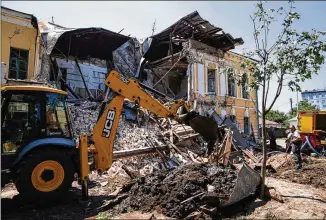  ?? EVGENIY MALOLETKA/AP ?? An excavator clears the rubble of a military registrati­on office that was destroyed by Russian attacks Wednesday in Kharkiv, the second-largest city and municipali­ty in Ukraine.