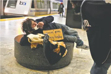  ?? Scott Strazzante / The Chronicle ?? Chad Cahill, who is homeless, is awakened as he tries to sleep at BART’s Civic Center Station.