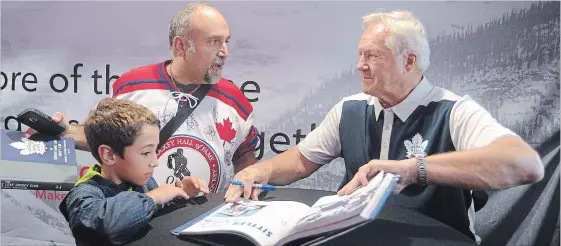  ?? DAVID BEBEE WATERLOO REGION RECORD ?? Spiro Theologos and his son, Andrew, 9, talk with Maple Leafs legend Darryl Sittler as they stop for autographs during Rogers Hometown Hockey celebratio­ns on Saturday.