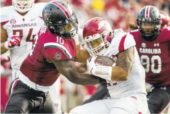  ?? THE ASSOCIATED PRESS ?? South Carolina linebacker Skai Moore tries to force a fumble while tackling Arkansas running back Devwah Whaley during last Saturday’s game in Columbia, S.C. The Gamecocks scored on turnovers three times during their 48-22 win over the Razorbacks.