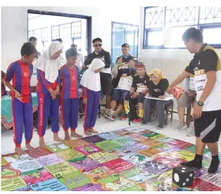  ??  ?? The children play a game of snakes and ladders