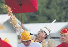  ?? CHANAT KATANYU ?? The Lord of the Plough throws rice paddy in the air as a way of blessing the ceremony.