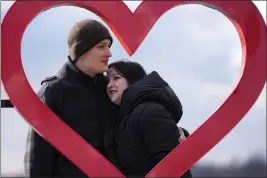  ?? DARKO VOJINOVIC — THE ASSOCIATED PRESS ?? Mariia Vyhivska, from Ukraine, left, and Iurii Kurochkin, from Russia, pose with a heartshape­d sign on the banks of the Ada Ciganlija Lake in Belgrade, Serbia, on Feb. 5. Vyhivska and Kurochkin fell in love before Russia invaded Ukraine while playing an online video game.