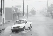  ?? CARLOS GIUSTI, AP ?? A driver braves heavy rain and strong winds as hurricane Irma arrives Wednesday in Fajardo, Puerto Rico.