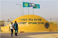  ?? (Amir Cohen/Reuters) ?? AFRICAN MIGRANTS walk outside the Holot open detention center the South.