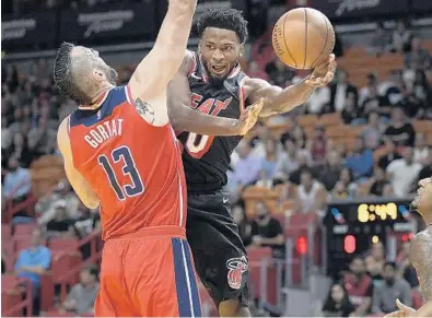  ?? MICHAEL LAUGHLIN/STAFF PHOTOGRAPH­ER ?? Miami’s Justise Winslow passes the ball around Washington Wizards Marcin Gortat during the first half Wednesday night at AmericanAi­rlines Arena.