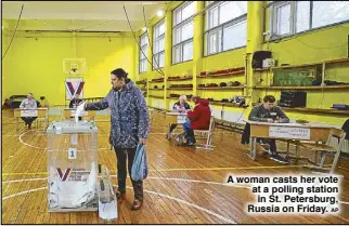 ?? AP ?? A woman casts her vote at a polling station in St. Petersburg, Russia on Friday.