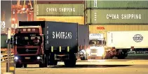  ?? (File photo) ?? Trucks transport shipping containers at a dockyard in Qingdao in east China’s Shandong province